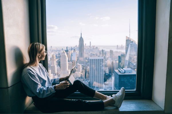 Women sitting by window looking out at city